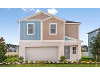 Charming two-story home boasts a modern color scheme, landscaped front yard and attached two car garage at 12842 Call Center Rd, Lithia, FL 33547