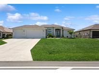 Charming single Gathering home with a lush green lawn, three-car garage, and beautiful landscaping at 180 Rotonda N Blvd, Rotonda West, FL 33947