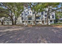 New white townhouse exterior featuring a brick road and mature trees on an idyllic street at 1801 N Morgan St # 5, Tampa, FL 33602