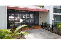 Exterior entrance with tiled walkway, covered awning, and glass doors leading into the building at 2593 Countryside Blvd # 7305, Clearwater, FL 33761