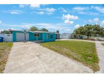 Charming single-story home with a bright blue exterior and a spacious front yard at 3215 58Th N St, St Petersburg, FL 33710