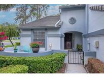 Charming home exterior features a gated courtyard with seating and garden, showcasing the property's curb appeal at 4234 Brentwood Park Cir, Tampa, FL 33624