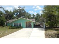 Ranch-style home boasts a welcoming porch, spacious driveway, and charming curb appeal at 5287 Azalea Cir, Dade City, FL 33523