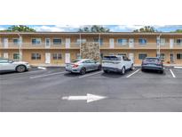 Exterior view of a two-story building with ample parking, featuring a stone accent wall at 8039 Garden Dr # 105, Seminole, FL 33777