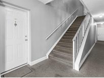 View of a carpeted stairwell in a home with a white front door at 9130 Tudor Dr # M105, Tampa, FL 33615