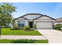 Charming single-story home features a well-maintained lawn, two-car garage, and inviting front entrance at 9647 Summers Cay Cir, Thonotosassa, FL 33592