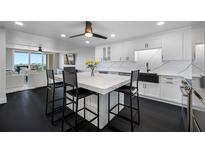 Modern kitchen features a center island with seating, white cabinets, and marble countertops, creating a bright and stylish space at 100 Oakmont Ln # 802, Belleair, FL 33756