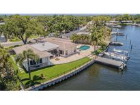 Stunning waterfront home featuring a private pool, dock, lush landscaping, and outdoor entertaining spaces at 1185 36Th Ne Ave, St Petersburg, FL 33704