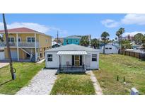 Charming single-story home featuring a cozy front porch and a classic white facade at 13124 4Th E St, Madeira Beach, FL 33708