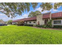 Charming single-story villa featuring a well-maintained lawn and beautiful landscaping at 1701 Pinehurst Rd # 9G, Dunedin, FL 34698