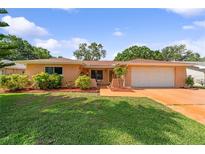 Charming single-story home with a lush green lawn and well-manicured landscaping in a desirable neighborhood at 1707 Hibiscus S Cir, Oldsmar, FL 34677