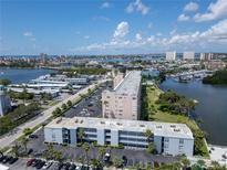 Real estate showing an aerial view of condo buildings with palm trees by a waterfront at 1859 Shore S Dr # 202, South Pasadena, FL 33707