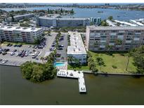 Gorgeous aerial view of the waterfront condo building, pool, boat dock and surrounding neighborhood on a sunny day at 1859 Shore S Dr # 202, South Pasadena, FL 33707