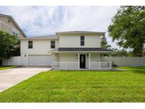 Inviting two-story home featuring a covered front porch and well-manicured lawn at 2807 57Th S St, Gulfport, FL 33707