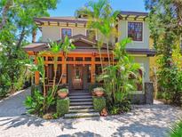 Beautiful two-story home featuring a wooden front porch and mature tropical landscaping at 3112 W Wallcraft Ave, Tampa, FL 33611