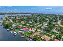 Stunning aerial view of a waterfront home in a lush neighborhood, with a private dock and easy access to the bay at 4099 Pompano Se Dr, St Petersburg, FL 33705
