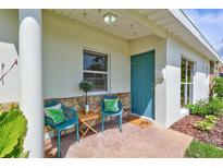 Inviting front porch with stone accents, seating, and a cheerful blue door at 4099 Pompano Se Dr, St Petersburg, FL 33705