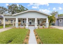 Charming craftsman-style bungalow featuring a covered front porch and well-manicured lawn at 419 W Osborne Ave, Tampa, FL 33603