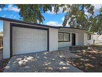 Charming single-story home featuring a white exterior, well-maintained garage, and inviting front porch at 5053 Lofton Dr, New Port Richey, FL 34652