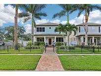 Charming two-story home with manicured lawn, mature palms, and a decorative fence at 510 33Rd N Ave, St Petersburg, FL 33704