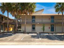Condo complex featuring reserved parking spaces and tropical palm trees on a sunny day at 6324 Newtown Cir # 24B1, Tampa, FL 33615