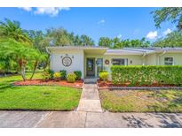 Charming home featuring a meticulously maintained front yard with vibrant green grass and decorative landscaping at 70 Cypress Pl, Oldsmar, FL 34677