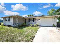 Charming single Gathering home with a brick facade, driveway, and front yard landscaping at 7810 Pineapple Ln, Port Richey, FL 34668