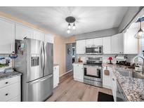 Modern kitchen with stainless steel appliances, granite countertops, and hardwood floors at 11348 59Th Ter, Seminole, FL 33772