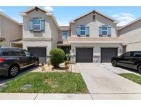 Charming two-story townhome with attached garages, manicured lawn, and stone accents at 12353 Bayou Flats Ln, Tampa, FL 33635