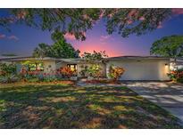 Charming single-story home featuring a well-maintained lawn and colorful landscaping, creating a welcoming curb appeal at 1766 Hitching Post Ln, Dunedin, FL 34698