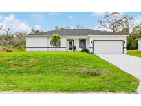 Charming single-story home with a well-maintained lawn and attached one car garage at 19233 Wilton Ave, Port Charlotte, FL 33954