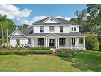 Stately two-story home showcasing a charming wrap-around porch and meticulous landscaping at 19803 Prince Benjamin Dr, Lutz, FL 33549