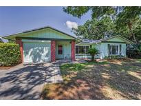 Inviting single-Gathering home with a well-maintained lawn, attached garage, and charming brick accents at 2212 Portside Psge, Palm Harbor, FL 34685