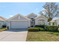 Charming single-story home featuring a well-manicured lawn and attached two-car garage at 2747 Wood Pointe Dr, Holiday, FL 34691