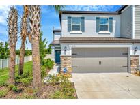 Charming two-story home with a gray two-car garage, stone accents and professionally landscaped front yard at 3228 Bryant Park Dr, New Port Richey, FL 34655