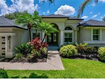 Charming single-story home boasts lush landscaping and a welcoming entrance with a dark-colored, double-door entry at 3909 Valrico Grove Dr, Valrico, FL 33594