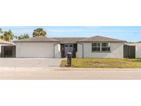 Charming one-story home featuring a large garage, tidy landscaping, and a freshly painted exterior at 6240 Keller Dr, Port Richey, FL 34668