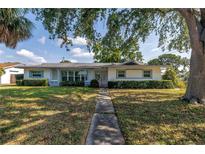Charming single-story home featuring a well-manicured lawn and mature shade trees at 6441 27Th N Ave, St Petersburg, FL 33710