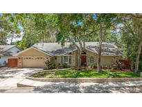 Charming single-story home with lush landscaping, a brick-accented facade, and a well-maintained front yard at 66 Bay Woods Dr, Safety Harbor, FL 34695