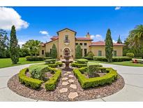 Stunning Mediterranean home with a circular driveway, fountain, and lush landscaping at 7713 Still Lakes Dr, Odessa, FL 33556