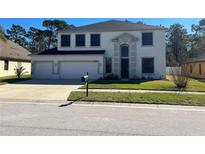 Charming two-story home with a well-manicured lawn and a spacious three car garage at 10826 Rain Lilly Pass, Land O Lakes, FL 34638