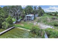 Lovely waterfront home on a large lot with a dock and screened balconies overlooking the lake at 11337 Knights Griffin Rd, Thonotosassa, FL 33592