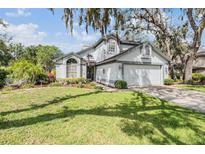Charming two-story home with a well-maintained lawn and mature trees creating a picturesque curb appeal at 15202 Heathridge Dr, Tampa, FL 33625