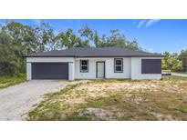 Newly constructed single-Gathering home with a modern black-and-white design and attached garage at 16134 Libourn Ave, Port Charlotte, FL 33954