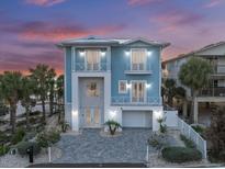 Stunning two-story blue home with white trim, balconies, a paved driveway, and tropical landscaping at 2 Gulf Blvd, Indian Rocks Beach, FL 33785