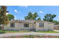 Charming single-story home with a neutral color scheme, complemented by lush landscaping and a well-manicured lawn at 2449 16Th N St, St Petersburg, FL 33704