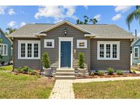 Charming home featuring a blue front door, landscaped yard, and brick pathway at 475 28Th N Ave, St Petersburg, FL 33704