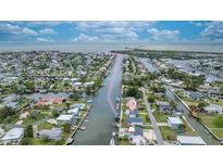 Aerial view of waterfront homes along canal with direct access to bay and the open waters beyond at 4976 Cedarbrook Ln, Hernando Beach, FL 34607