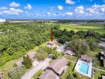 An aerial view of condos and beautiful greenery showcasing the community pool and surrounding landscape at 507 E Curlew Pl, Tarpon Springs, FL 34689