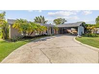 Charming single-story home with a long driveway, carport, lush landscaping, and lovely curb appeal at 5109 Vinson Dr, Tampa, FL 33610